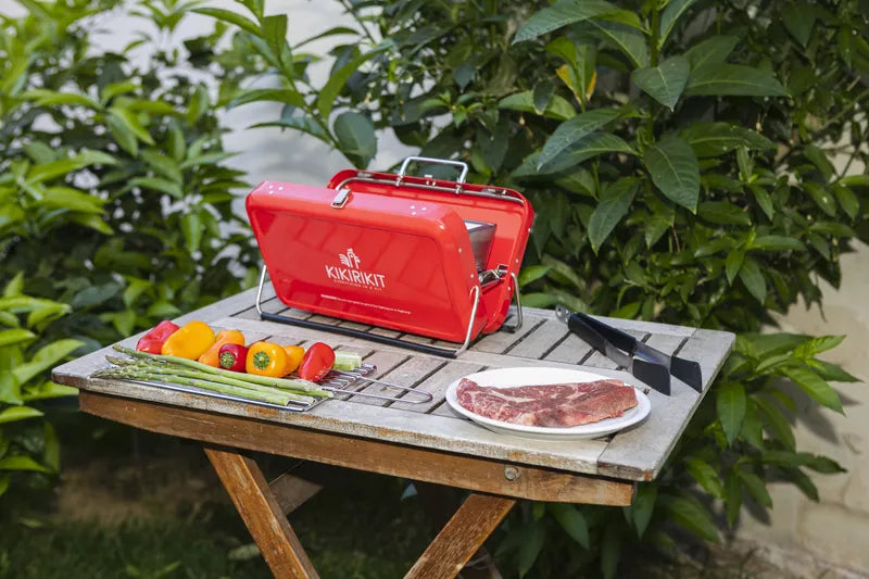 Barbecue à charbon pliable portatif de kikirikit rouge - Mise en situation sur une table  avec des aliments