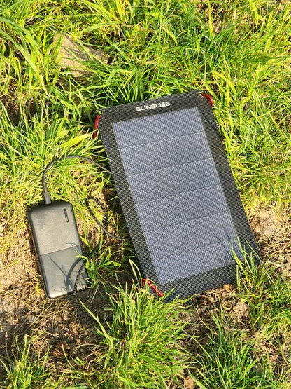 Chargeur solaire ultraléger et compact de Sunslice-  mise en situation sur l'herbe du Flex 6W qui charge un GSM