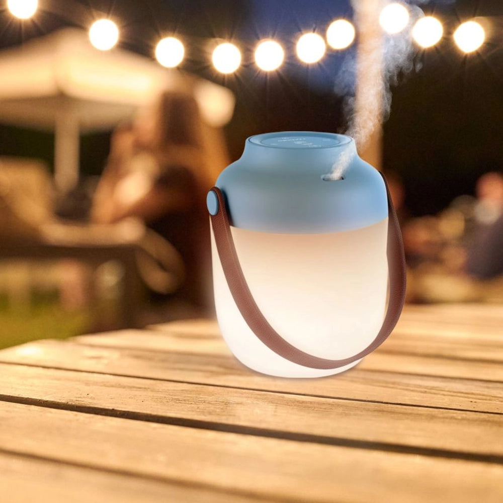 Diffuseur d’huiles essentielles et lanterne portable – mise en situation avec le système de diffusion actif sur une table d'extérieure