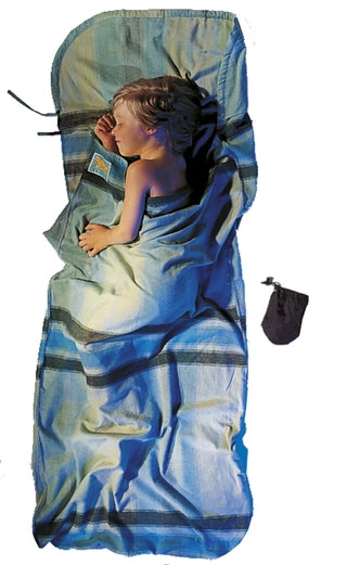 Housse de voyage en flanelle pour enfant de Cocoon - bleu - Mise en situation : un enfant dort dans la housse de lit avec la pochette posée à côté