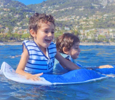 Enfant jouant dans l'eau sur le matelas Plouf