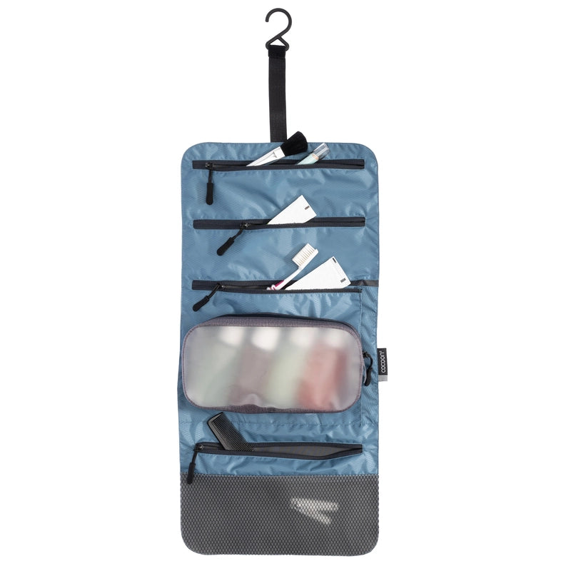 Trousse de toilette accrochable Cocoon – bleu – vue dépliée avec des articles de toilette à l’intérieur.