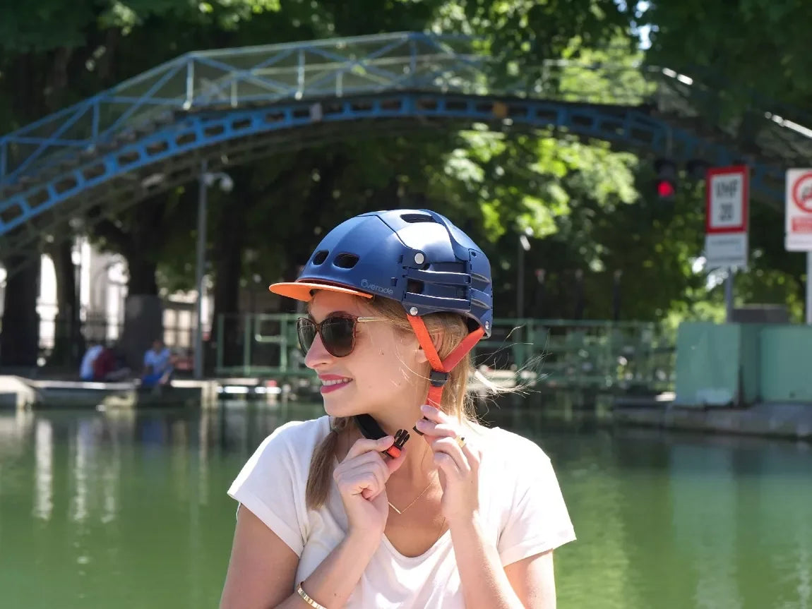 Casque bleu pliable Overade – mise en situation : porté sur la tête d’une femme avec une visière orange
