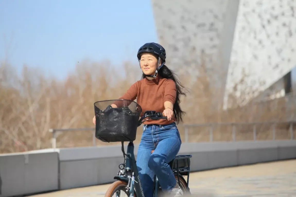 Casque pliable noir Overade – mise en situation : porté par une femme à vélo