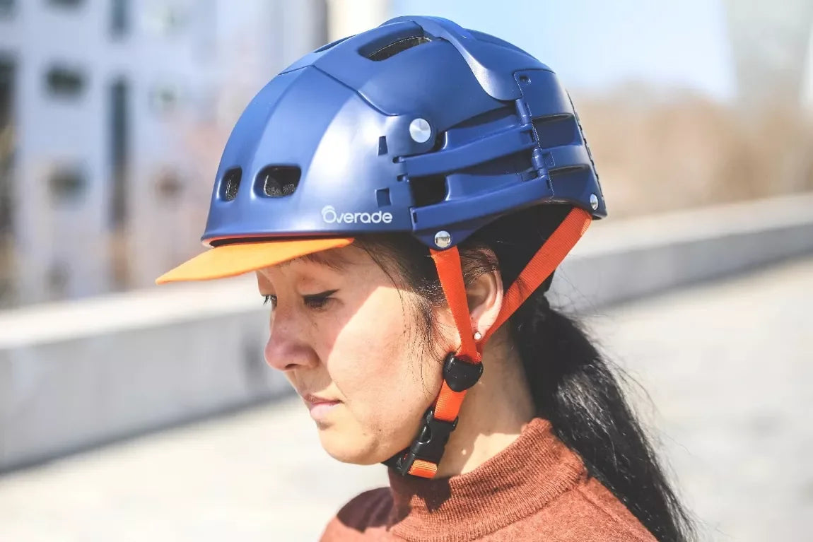 Casque pliable bleu Overade – mise en situation : porté par une femme avec visière orange