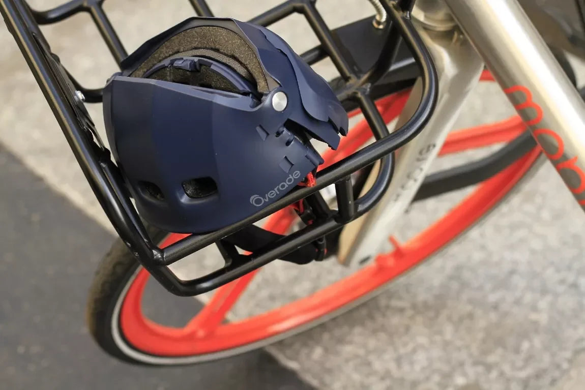 casque pliable bleu Overade fermé - mise en situation du casque en version fermée sur le porte bagage d'un vélo